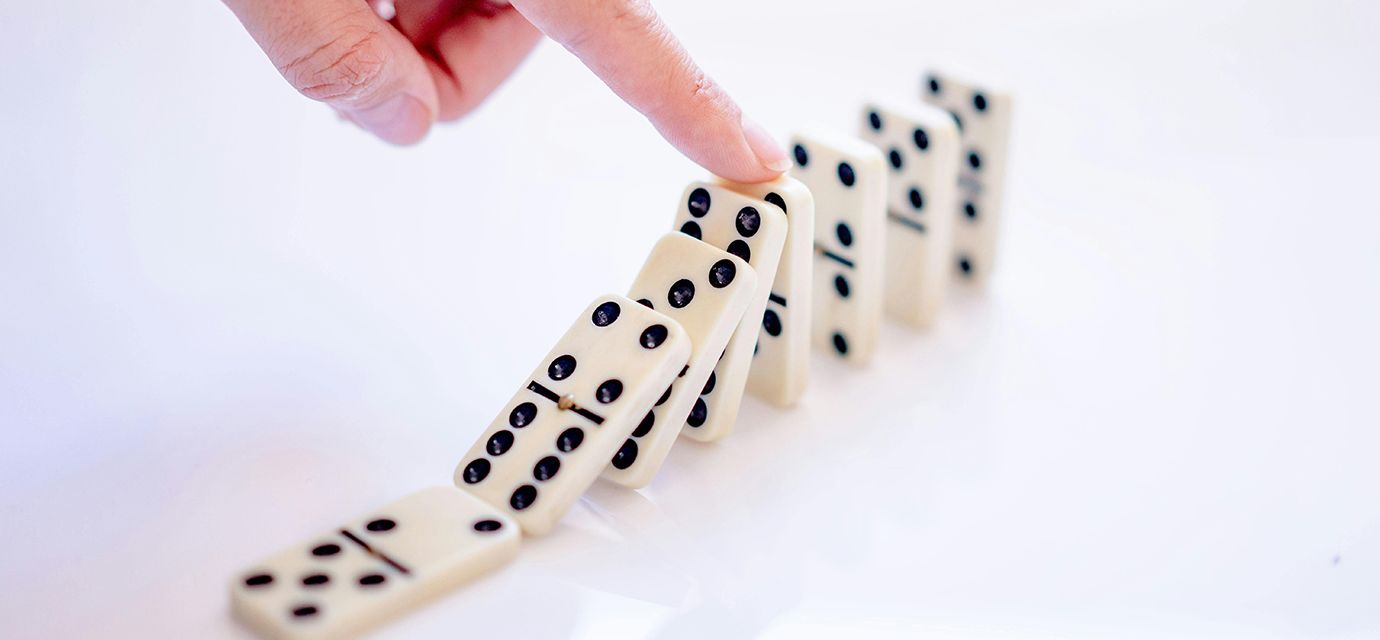 A finger pushing dominos.